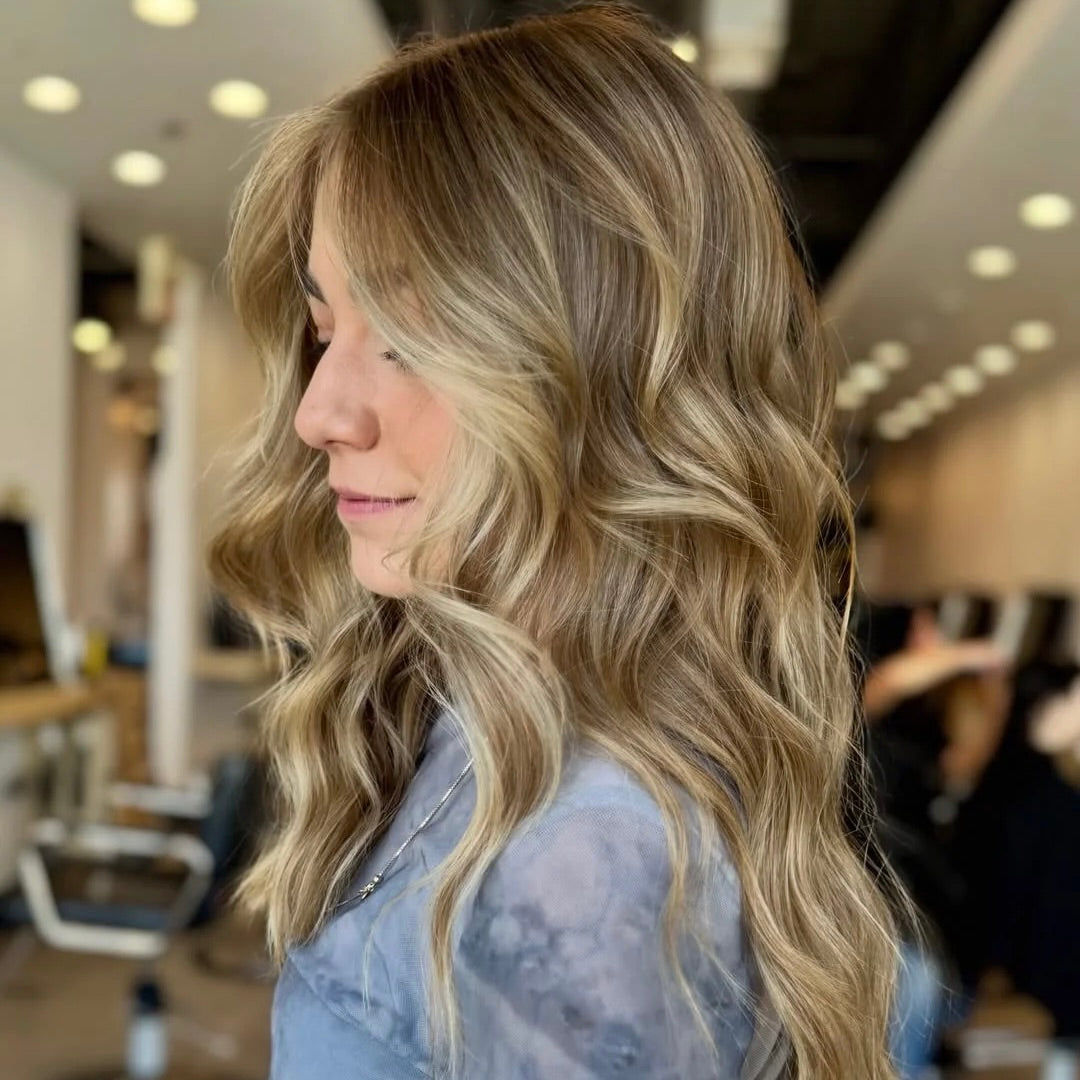 Dimensional blonde highlights and beach waves styled at Curious Salons Calgary — fall hair colour refresh