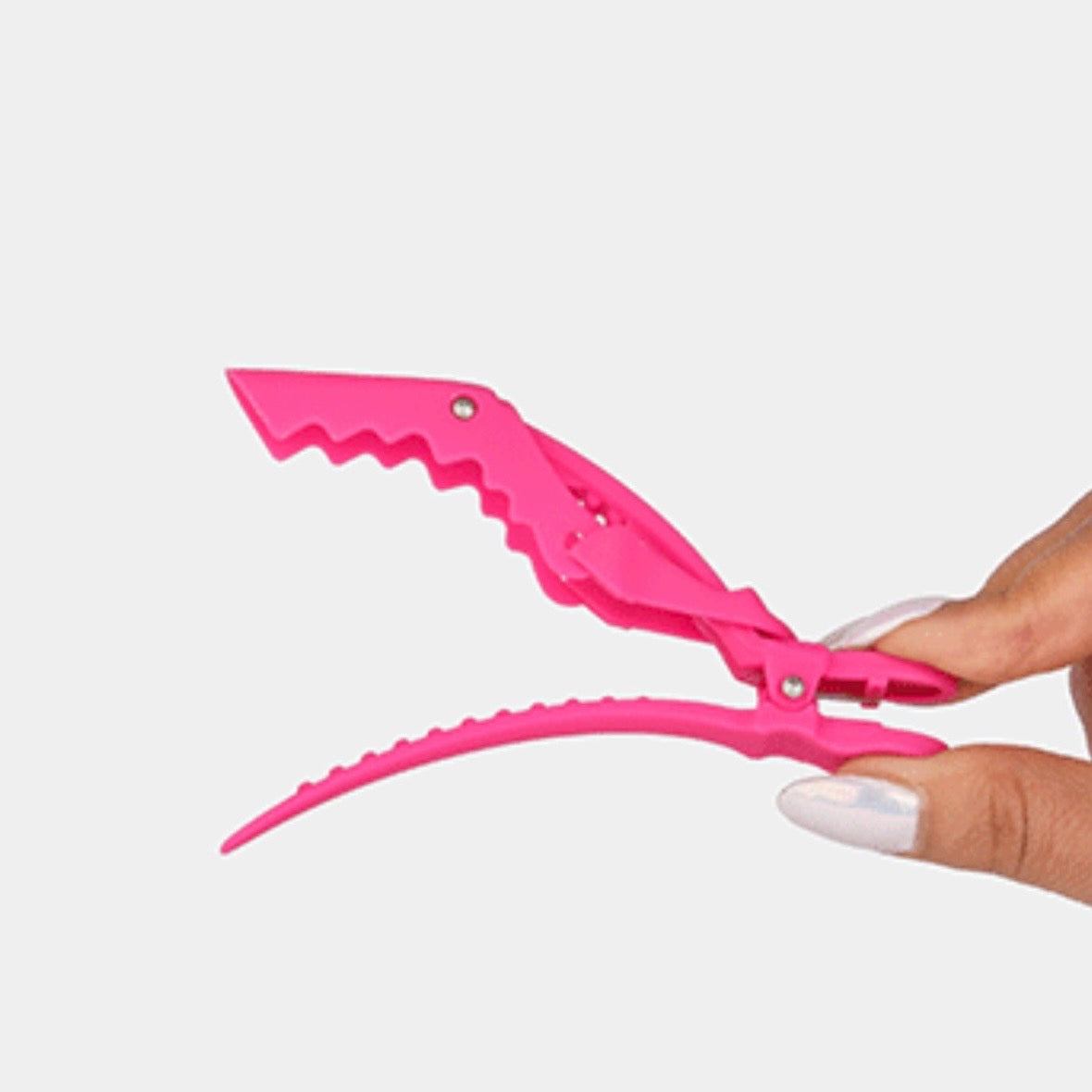 Hand holding a pink Framar hair sectioning clip