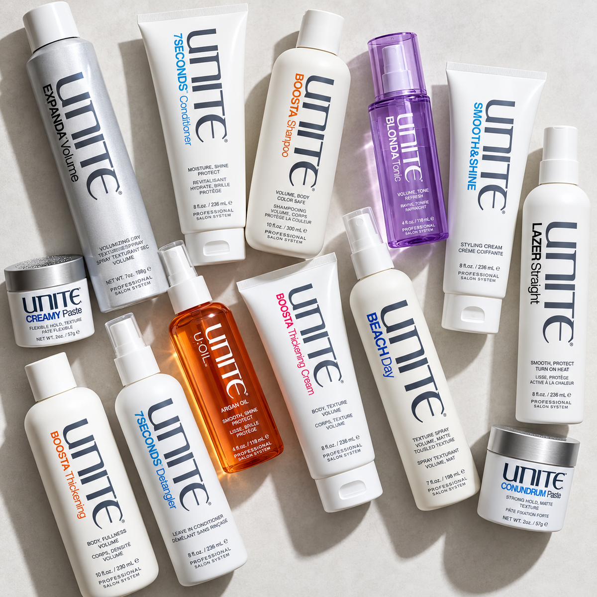 Assorted UNITE haircare and styling products on a light surface