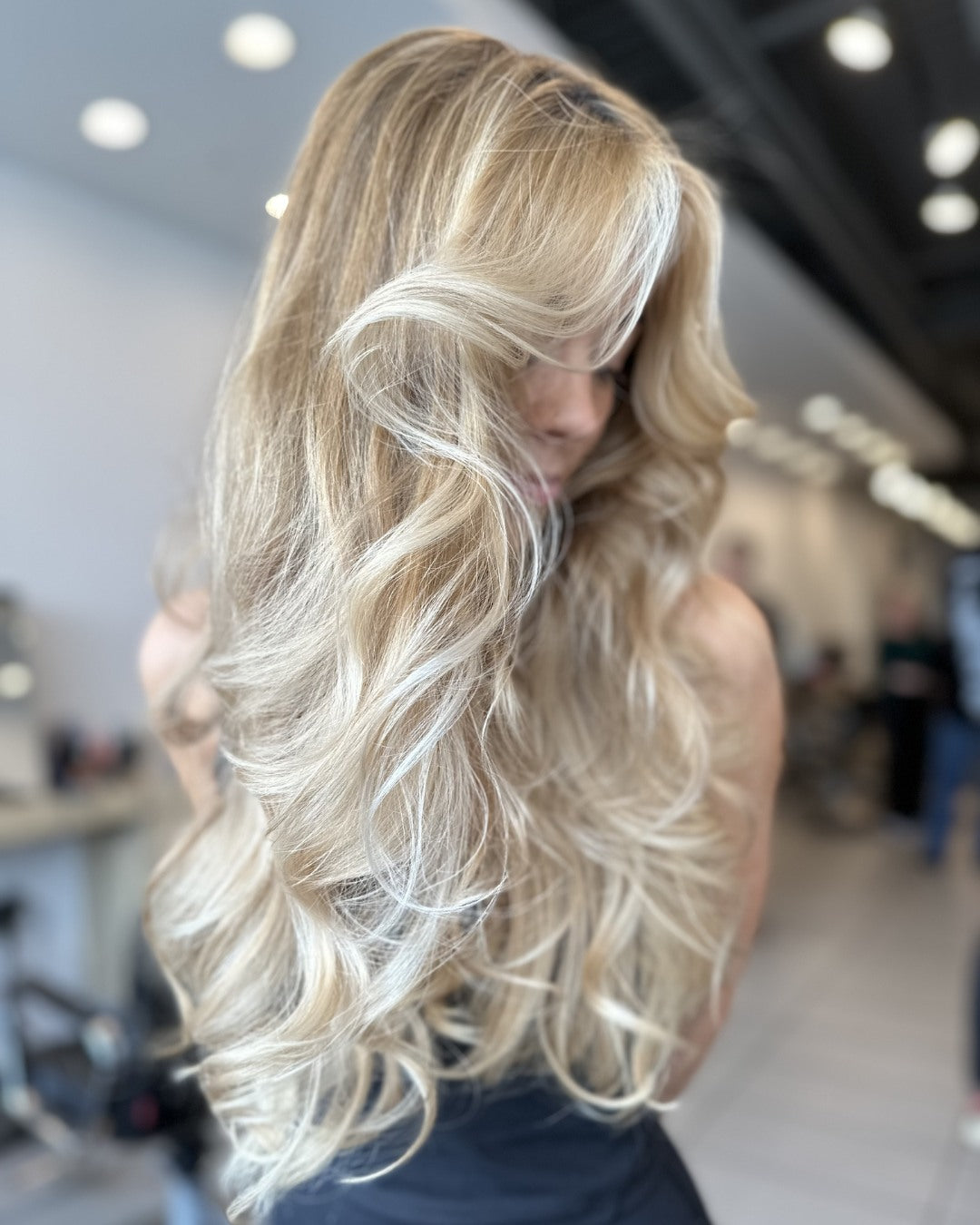 Woman wearing a blue fishnet top with a scenic background KEVIN.MURPHY SHIMMER.ME BLONDE shine treatment for blonde highlighted and grey hair