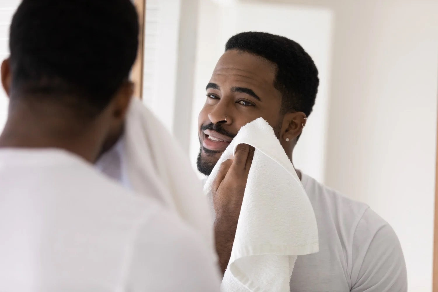Man styling hair with professional grooming products — shop men's hair care, beard care and styling at Curious Salons Canada