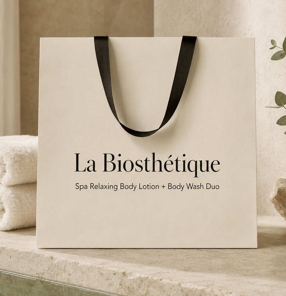 A cream-colored La Biosthétique spa gift bag with black handles, shop Curious Salons 