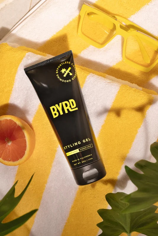 BYRD styling gel tube on a yellow and white striped towel with a grapefruit and leaves.