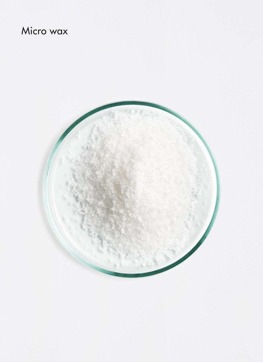 White powder in a glass container on a light gray background