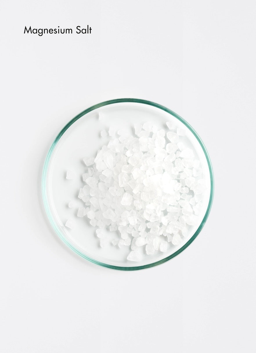 Glass bowl filled with magnesium salt on a white background