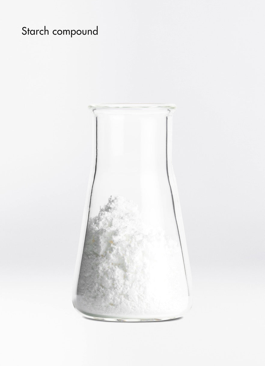 Clear glass beaker filled with a white powdery substance on a white background