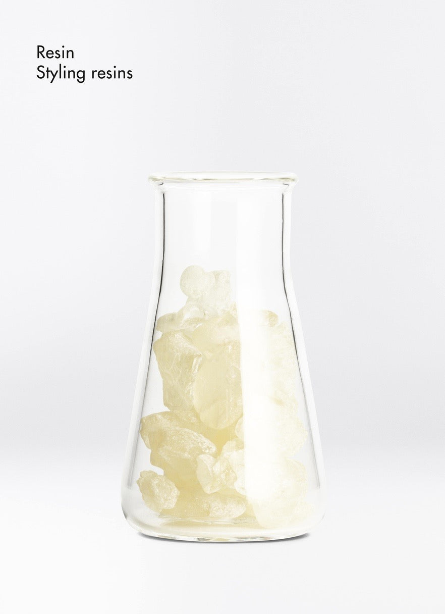 Clear glass container with white resin inside on a white background