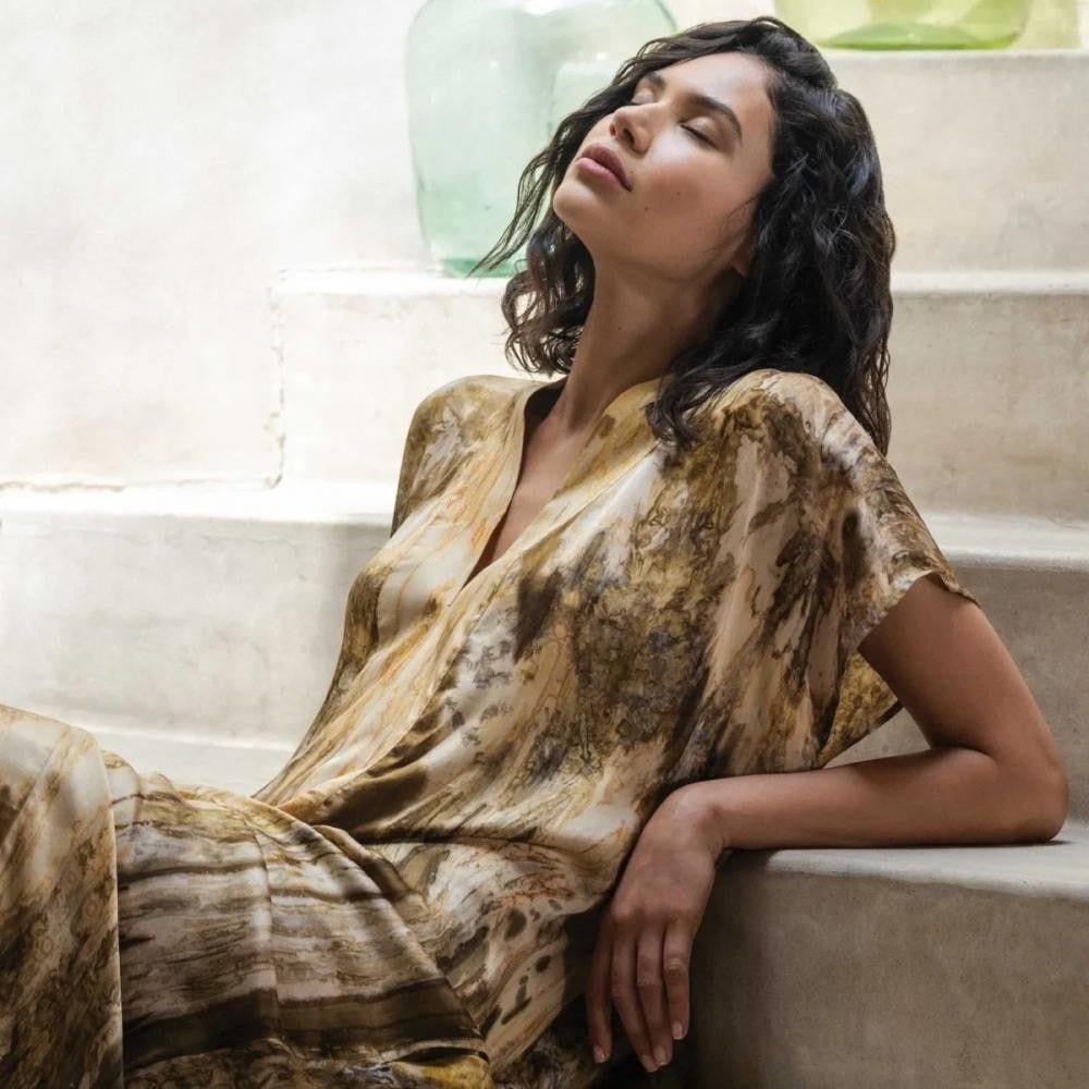 Woman in a patterned dress sitting on a staircase