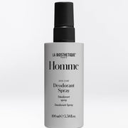 A 100ml bottle of La Biothetique Homme Deodorant Spray on a light gray background. The bottle is a light gray color with a black spray nozzle and black text on the label.