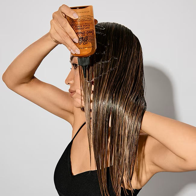 Woman applying hair with Bumble and bumble Bond-Building TripleBond Flash Rinse for damaged colour-treated hair in Canada