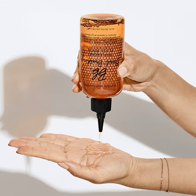 Hand holding a bottleBumble and bumble Bond-Building TripleBond Flash Rinse for damaged colour-treated hair in Canada
