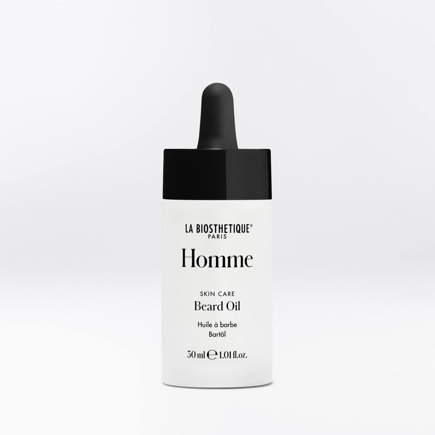 La Biosthetique Homme Beard Oil in a white bottle with a black dropper cap, centered on a light gray background.