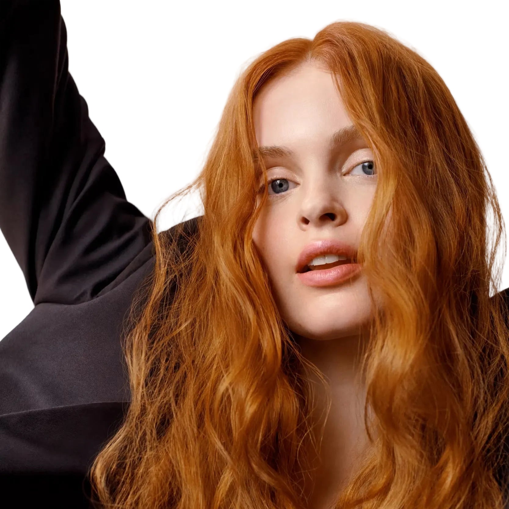 Woman with long wavy red hair against a neutral background