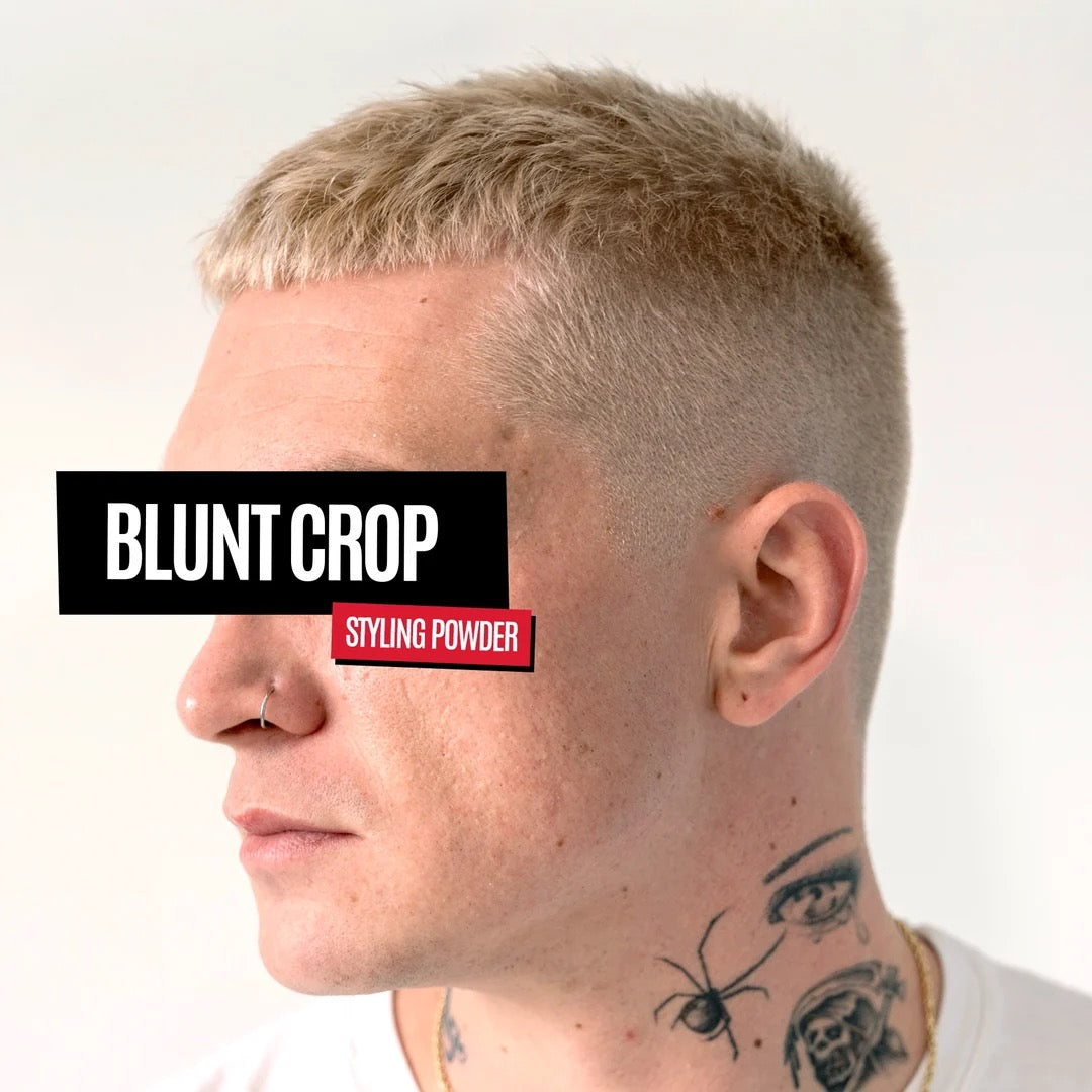 Side profile of a man with a short blonde 'blunt crop' haircut, wearing a black and red sticker overlay that reads 'BLUNT CROP' and 'STYLING POWDER'.