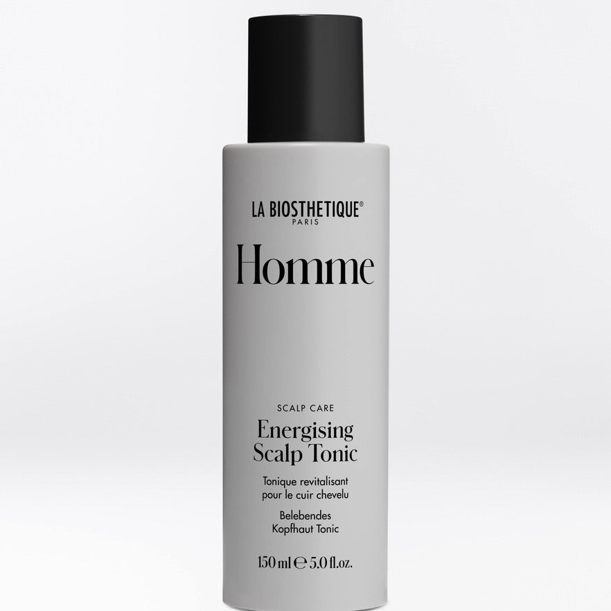 A 150ml bottle of La Biothétique Paris Homme Energising Scalp Tonic, featuring a matte light gray bottle and a black cap, set against a clean white background.