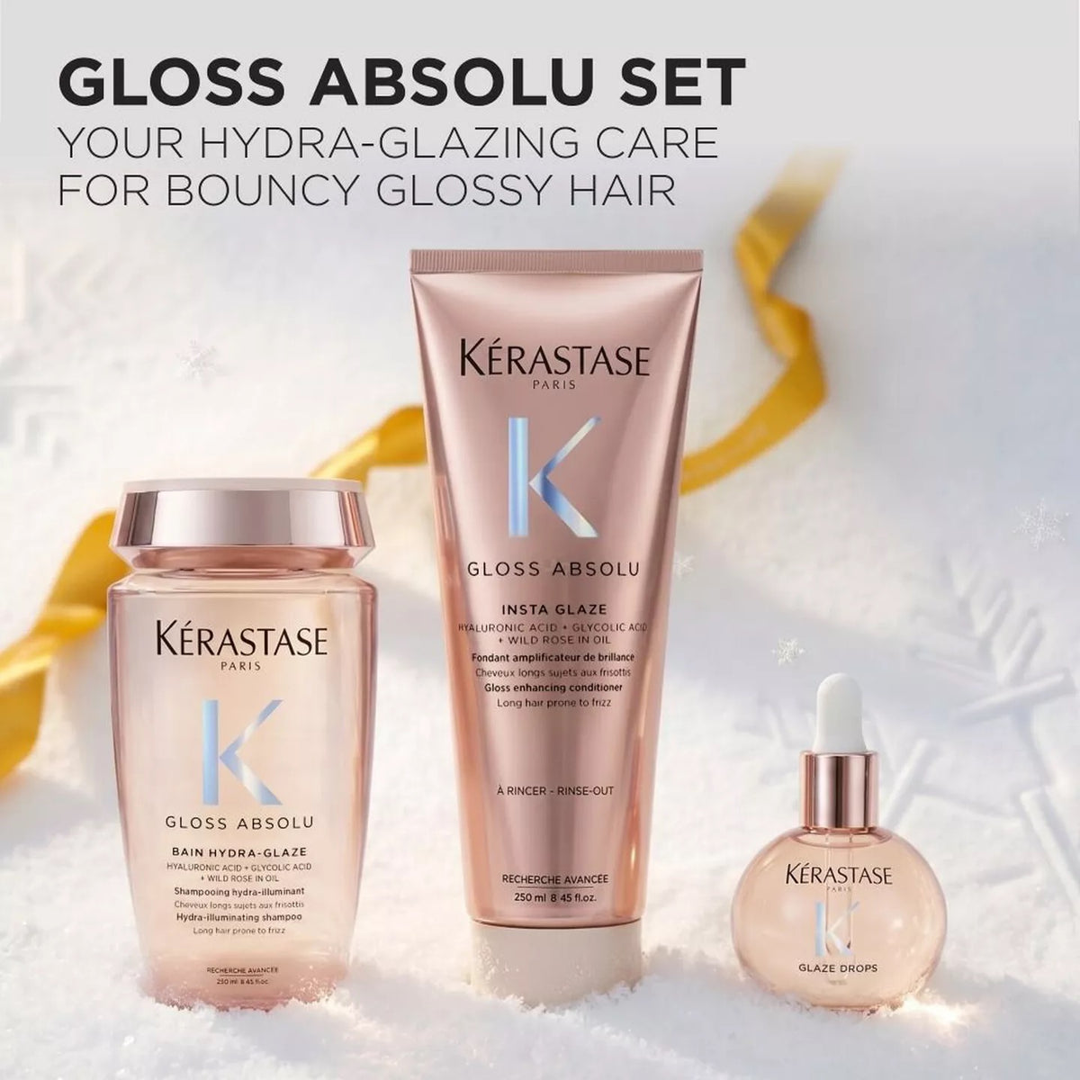 Kérastase Gloss Absolu hair care set featuring a Bain Hydra-Glaze bottle, an Insta Glaze tube, and a Glaze Drops perfume bottle, all in a soft pink and rose gold color with metallic rose gold caps, set against a white textured background with a gold ribbon.