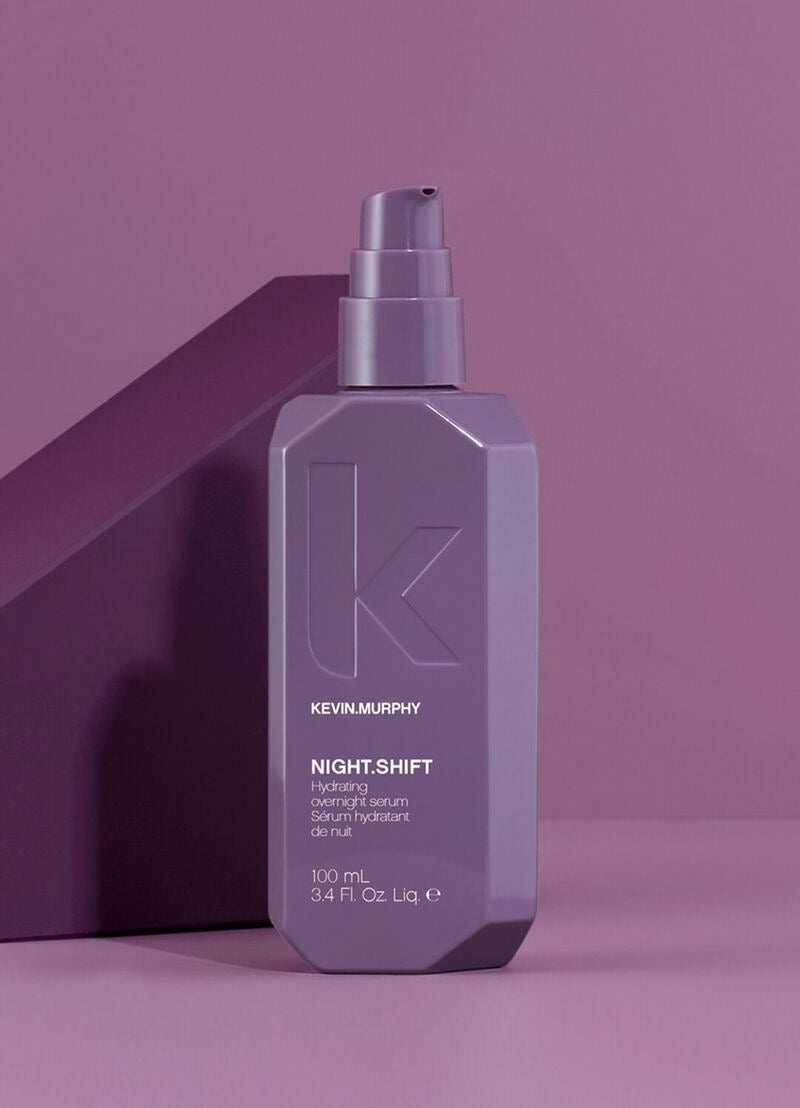 Kevin Murphy Night Shift Hydrating Overnight Serum in a matte lavender-purple bottle with a matching pump dispenser, set against a matching purple background with a geometric shadow.