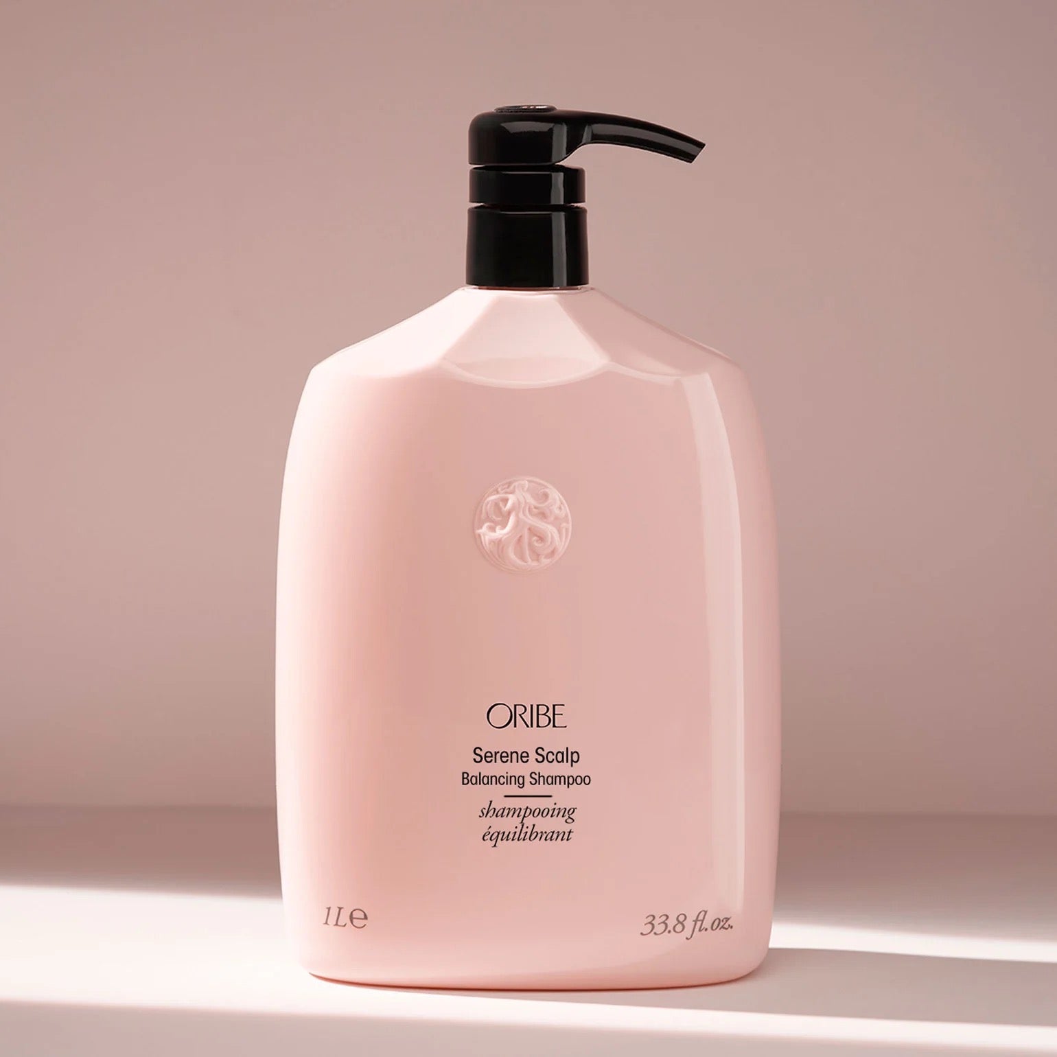 Pink shampoo bottle with black pump on a Oribe Serene Scalp Balancing Shampoo for dry flaky scalp care in Canada