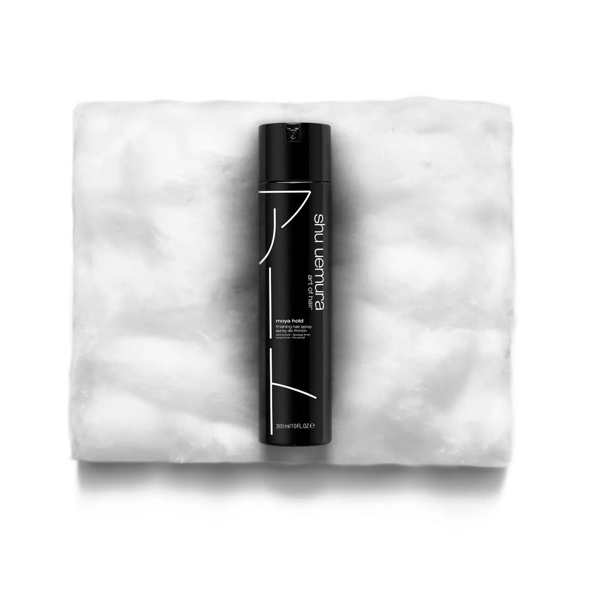 Black hair product bottle on a white towel with 'Sculpt' branding.