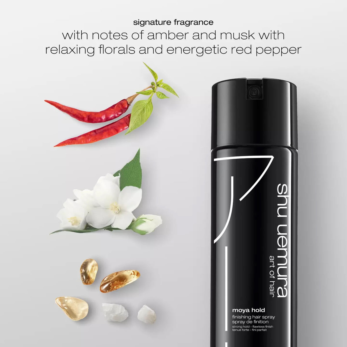 Shu Uemura hair spray bottle with flowers, red peppers, and gold elements on a light gray background