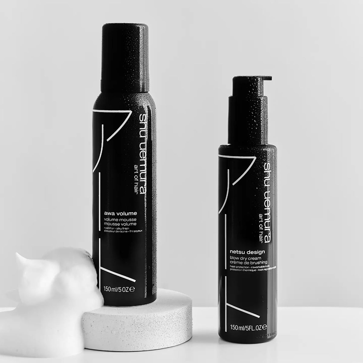 Two black hair product bottles by Shu Uemura on a white background