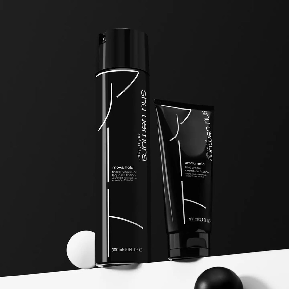 Two black hair care products with white text on a black background
