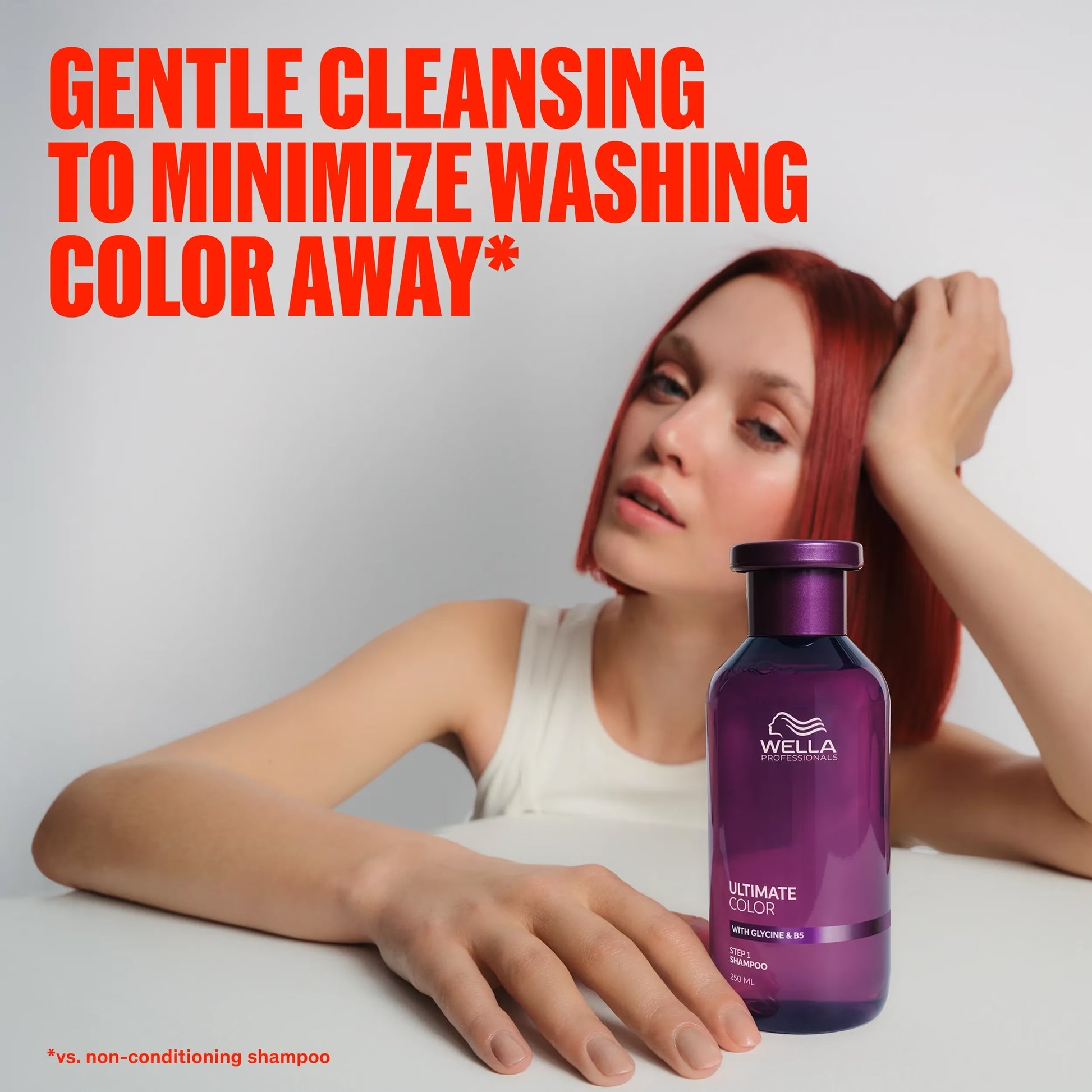 Woman with red hair next to a purple Wella bottle of Wella Ultimate Color Sulfate-Free Shampoo for colour-treated hair at Curious Salons Canada